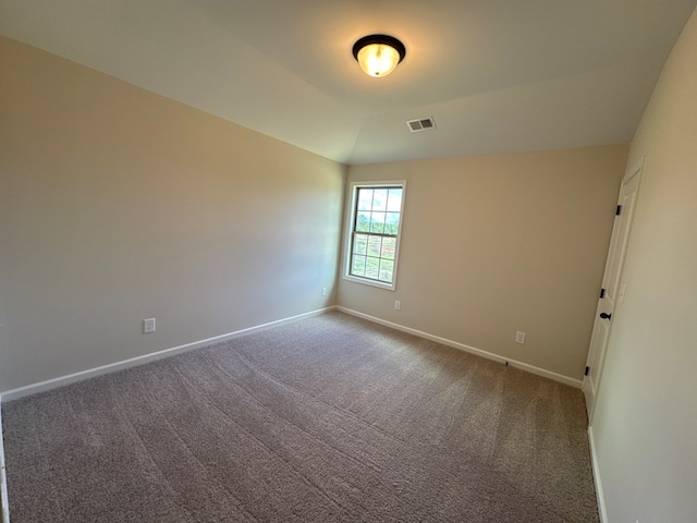 spare room featuring lofted ceiling and carpet floors