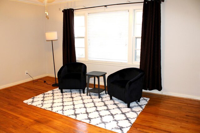 unfurnished living room featuring hardwood / wood-style flooring, crown molding, ceiling fan, and a brick fireplace