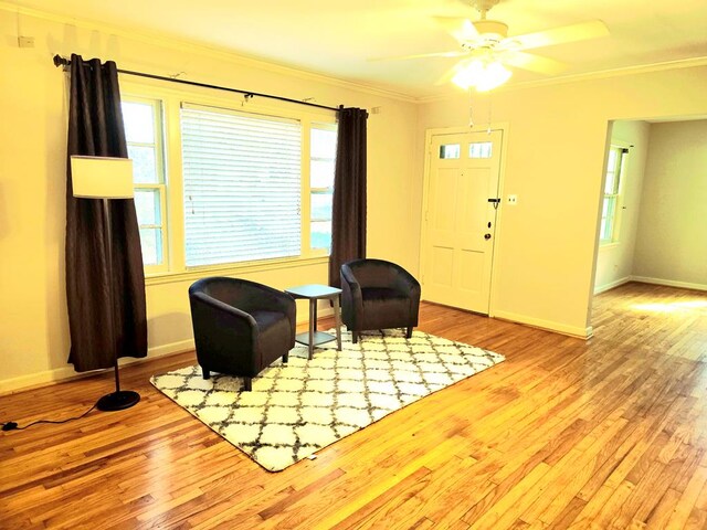 unfurnished living room with ceiling fan, light wood-type flooring, and ornamental molding