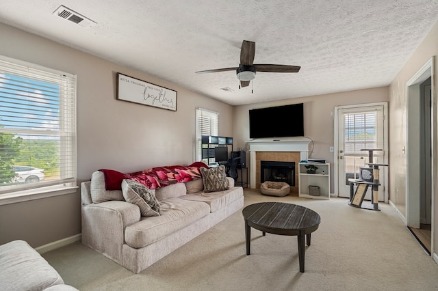 701 Crestline Dr, Columbus, GA 31907 - carpeted living room featuring plenty of natural light, a ceiling fan, a tiled fireplace, and a textured ceiling