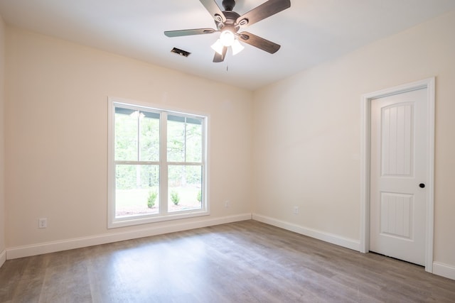 unfurnished room featuring wood finished floors, baseboards, and a ceiling fan