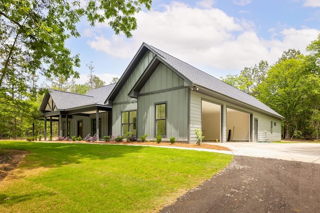 view of front of property featuring a shingled roof, board and batten siding, a front yard, and driveway