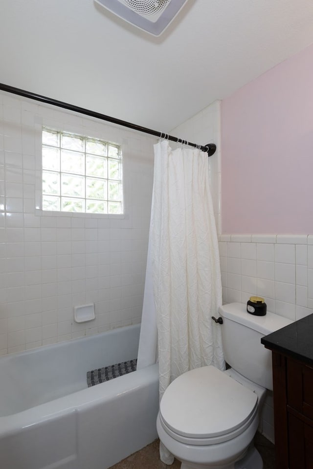 bathroom featuring tile walls, a wainscoted wall, shower / bath combination with curtain, and toilet