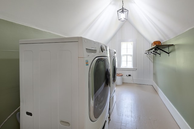 washroom featuring baseboards, washer and dryer, and laundry area
