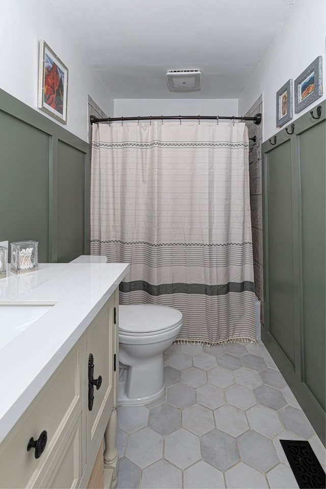 full bathroom with curtained shower, toilet, and vanity