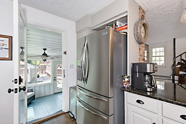 kitchen with dark wood finished floors, a textured ceiling, white cabinetry, and stainless steel fridge with ice dispenser