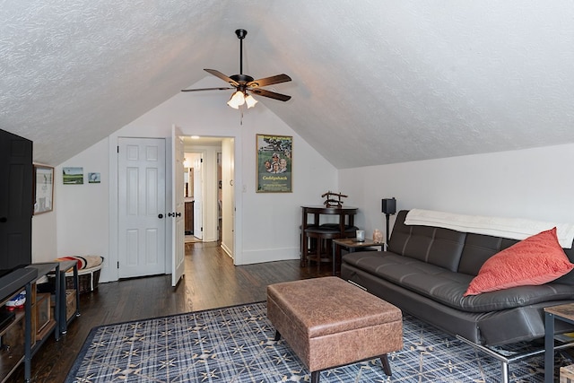 living room featuring lofted ceiling, wood finished floors, a ceiling fan, baseboards, and a textured ceiling