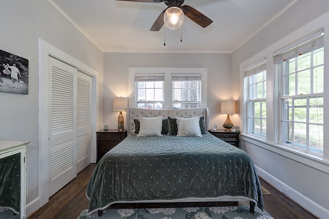 bedroom featuring dark wood-style flooring, a closet, ornamental molding, and multiple windows