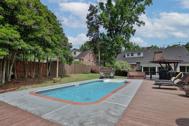 view of swimming pool featuring a fenced backyard, a wooden deck, and a fenced in pool