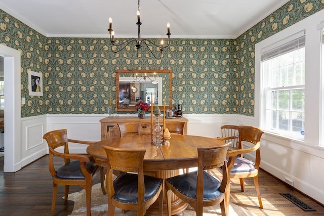 dining space with wainscoting, wood finished floors, visible vents, and crown molding