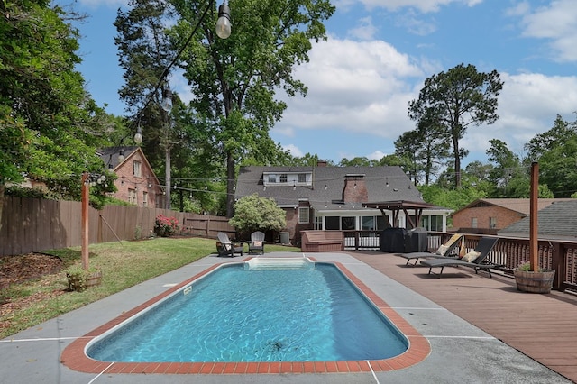 view of swimming pool featuring a wooden deck, a fenced in pool, a lawn, and a fenced backyard