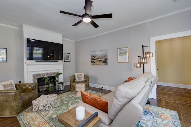 living area with wood finished floors, crown molding, baseboards, a fireplace, and ceiling fan