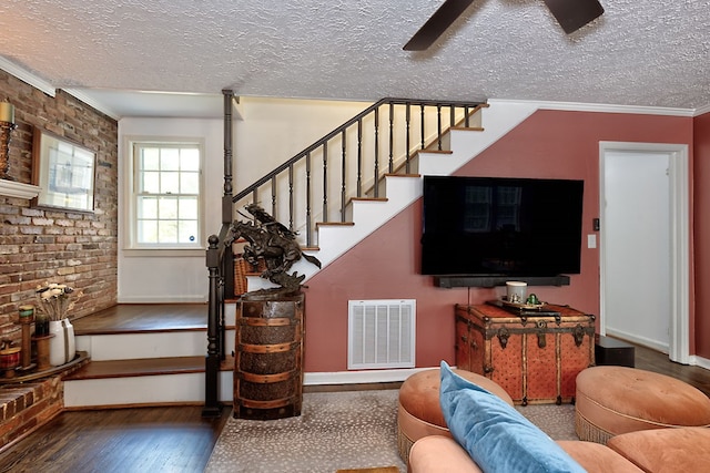 living room with wood-type flooring, a textured ceiling, stairway, and visible vents