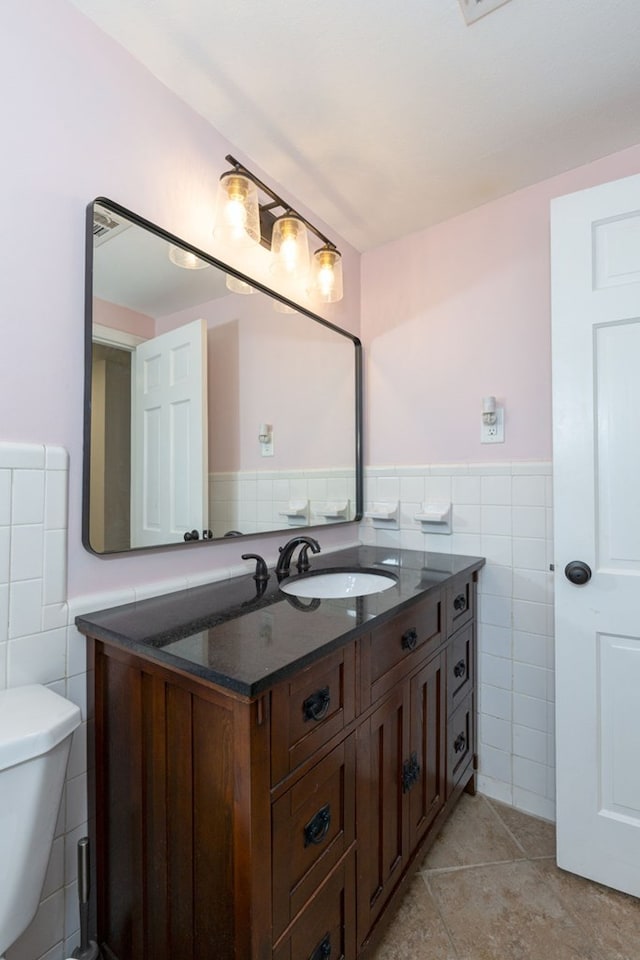 bathroom featuring tile walls, tile patterned floors, vanity, and a wainscoted wall