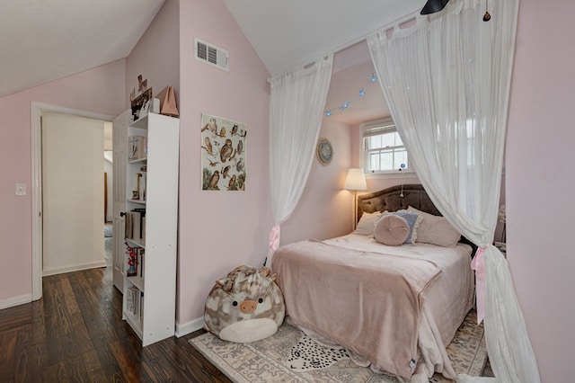 bedroom with lofted ceiling, baseboards, wood finished floors, and visible vents
