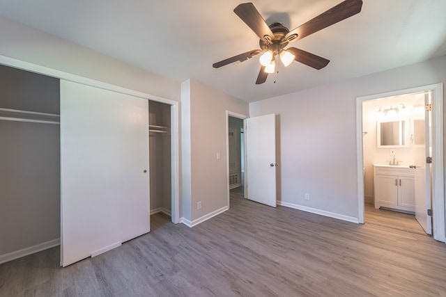 unfurnished bedroom featuring connected bathroom, ceiling fan, light hardwood / wood-style flooring, and sink