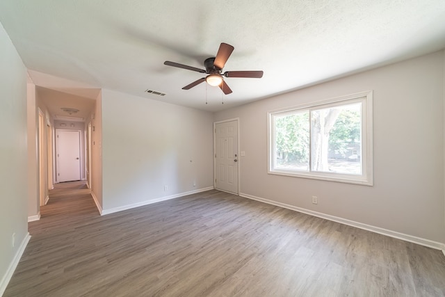 unfurnished room featuring a textured ceiling, hardwood / wood-style flooring, and ceiling fan