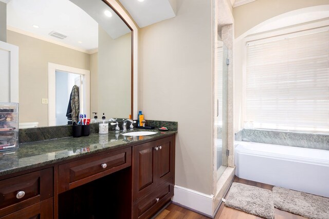 full bathroom featuring visible vents, wood finished floors, a shower stall, crown molding, and vanity