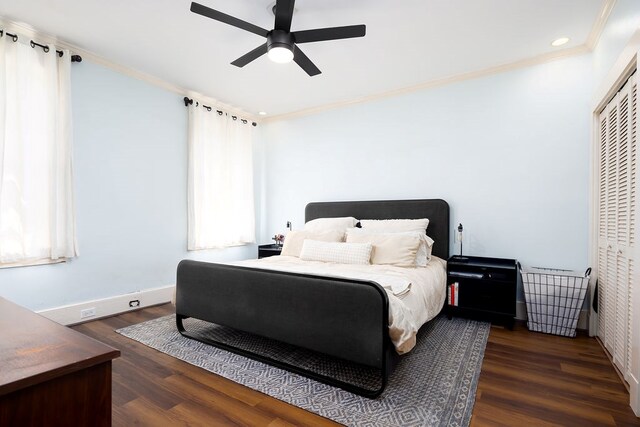 bedroom with baseboards, crown molding, and wood finished floors