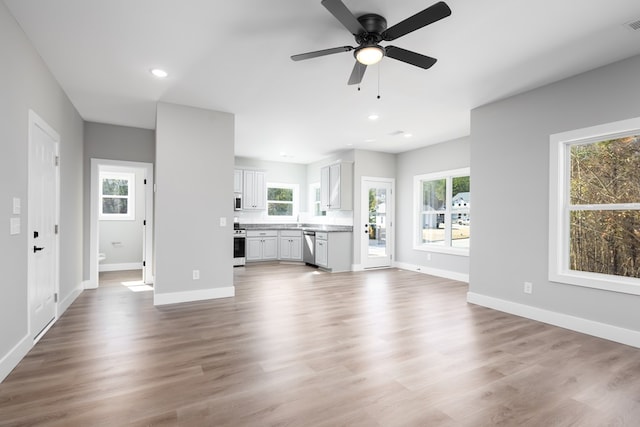 unfurnished living room featuring ceiling fan and light hardwood / wood-style flooring