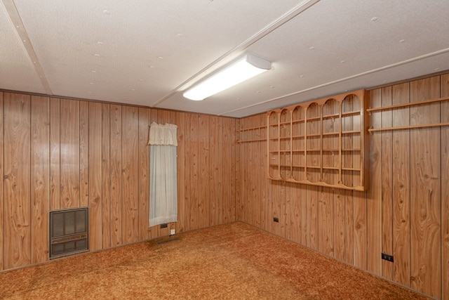 empty room featuring carpet and wooden walls