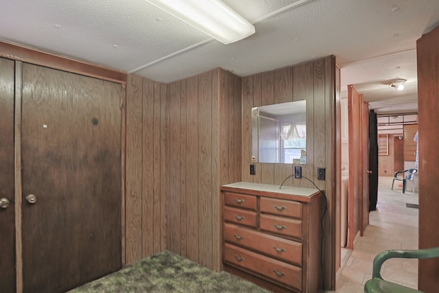 bathroom featuring vanity, a textured ceiling, and wood walls