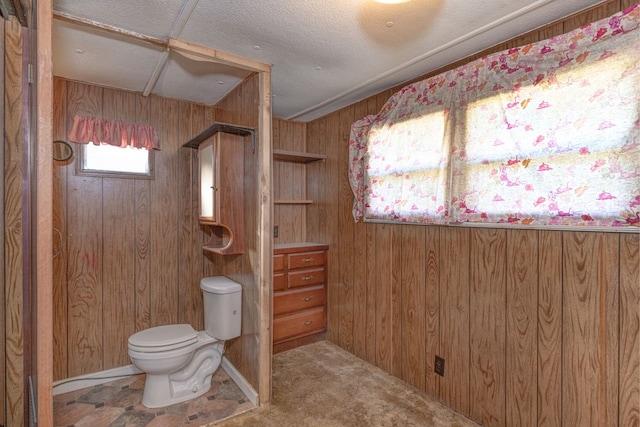 bathroom with wooden walls and toilet