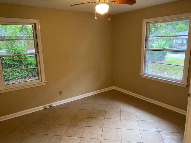 unfurnished room with light tile patterned floors, plenty of natural light, and ceiling fan