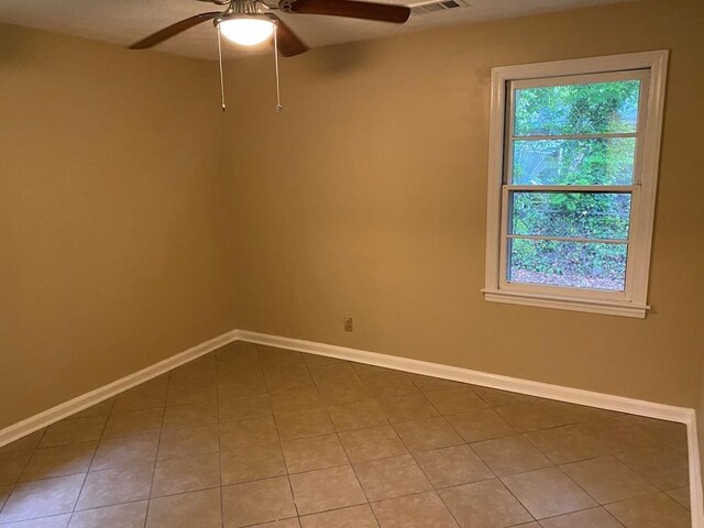 empty room with tile patterned floors and ceiling fan