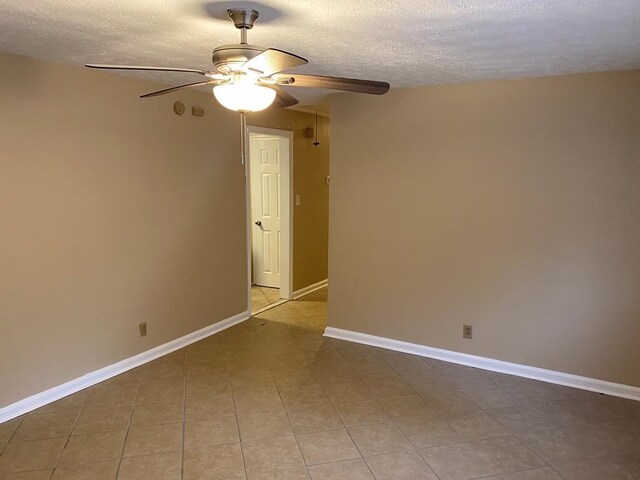 tiled spare room with a textured ceiling and ceiling fan