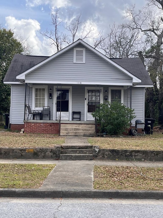 bungalow-style house featuring covered porch and roof with shingles