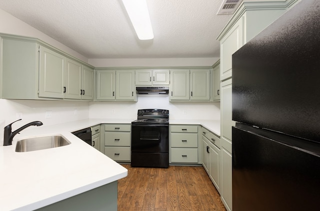 kitchen featuring visible vents, a sink, light countertops, black appliances, and under cabinet range hood