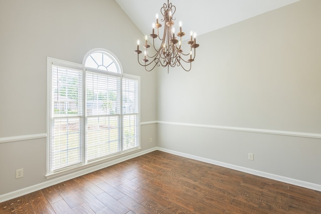 empty room with baseboards, a notable chandelier, high vaulted ceiling, and dark wood-type flooring