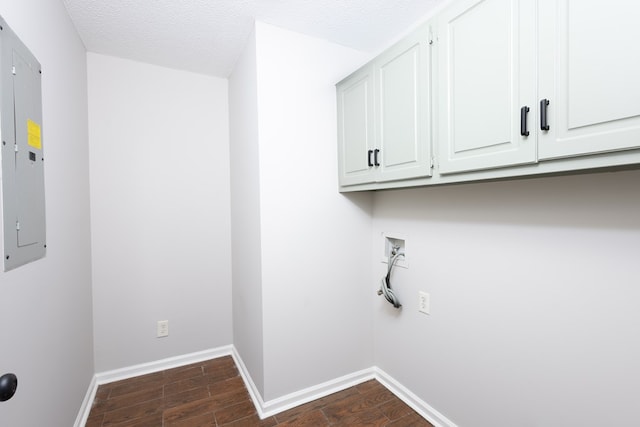 washroom with cabinet space, washer hookup, dark wood finished floors, baseboards, and electric panel