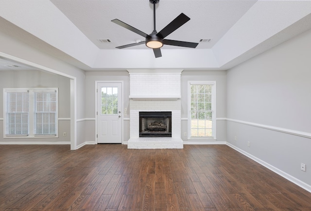 unfurnished living room with ceiling fan, vaulted ceiling, dark wood-style flooring, and visible vents
