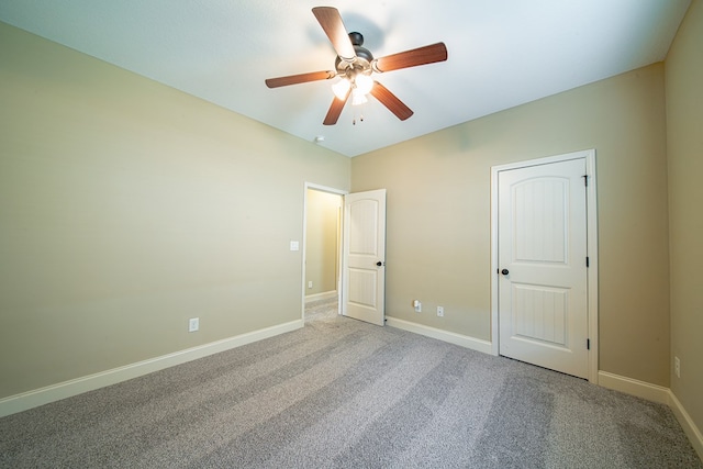 unfurnished bedroom featuring a ceiling fan, carpet, and baseboards