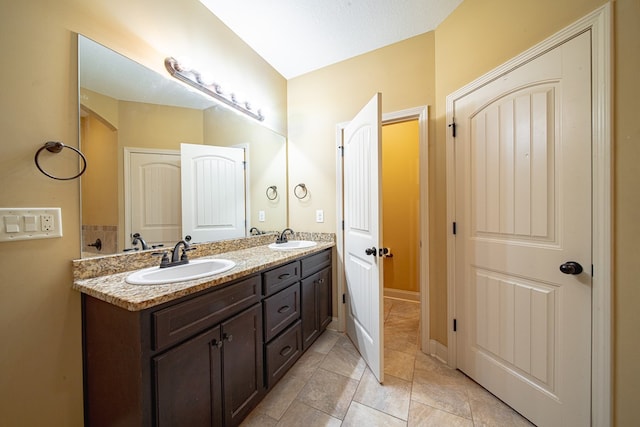 full bathroom featuring double vanity and a sink