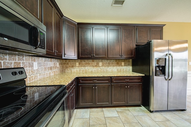 kitchen featuring dark brown cabinets, visible vents, tasteful backsplash, and appliances with stainless steel finishes