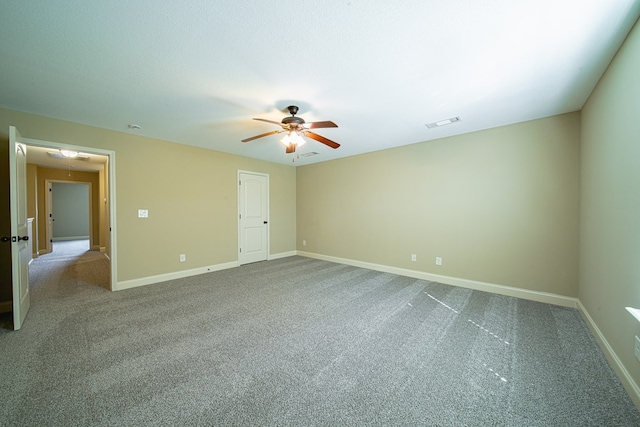 spare room with visible vents, attic access, carpet, and baseboards