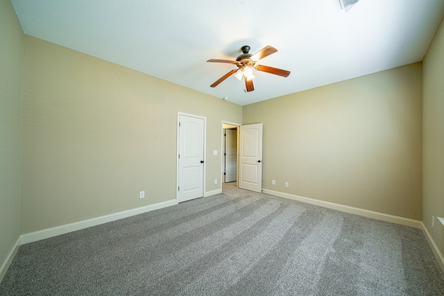 carpeted empty room with baseboards and a ceiling fan