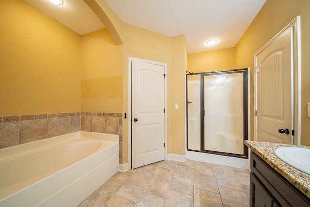 full bath featuring vanity, a bath, baseboards, and a stall shower