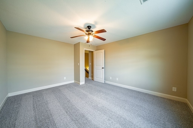 carpeted empty room featuring baseboards and a ceiling fan