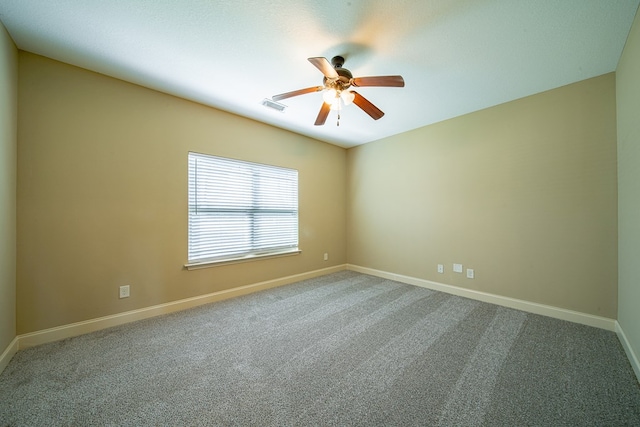 carpeted empty room with visible vents, baseboards, and ceiling fan