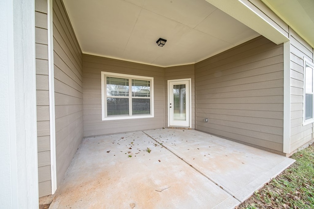 view of exterior entry with a patio