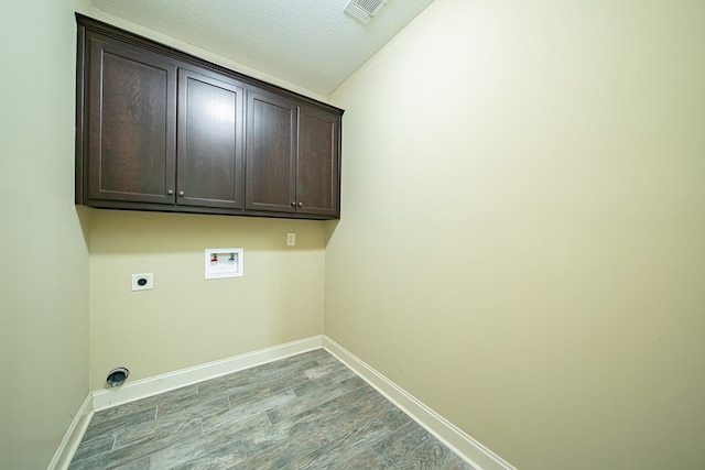 laundry area featuring wood finished floors, visible vents, hookup for an electric dryer, cabinet space, and washer hookup