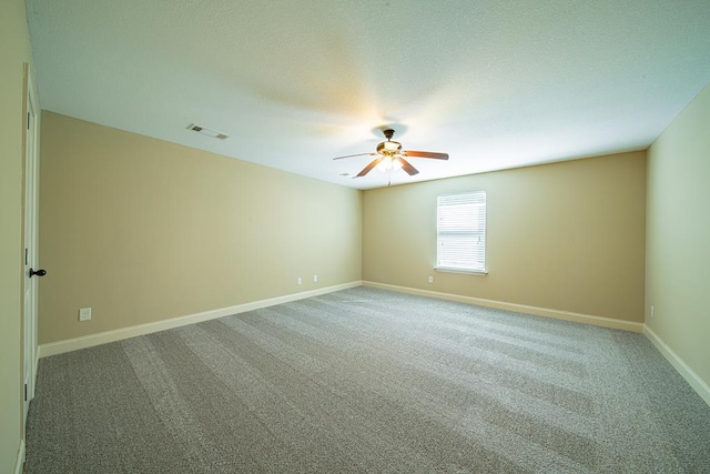 empty room featuring a ceiling fan, baseboards, visible vents, a textured ceiling, and light carpet