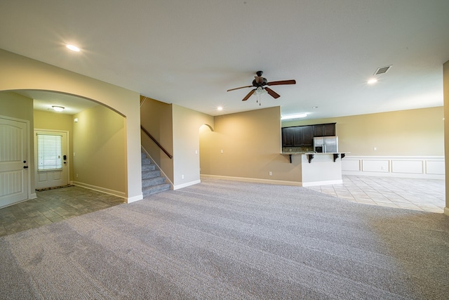 empty room with visible vents, stairs, light carpet, recessed lighting, and arched walkways