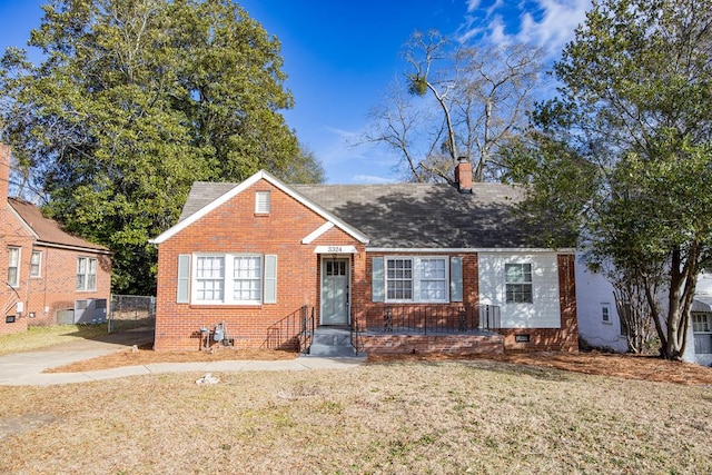 view of front of home featuring cooling unit and a front lawn