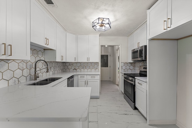 5437 Chatham Woods Ct, Columbus, GA 31907 - kitchen featuring stainless steel appliances, light stone counters, white cabinets, light marble finish floors, and a peninsula