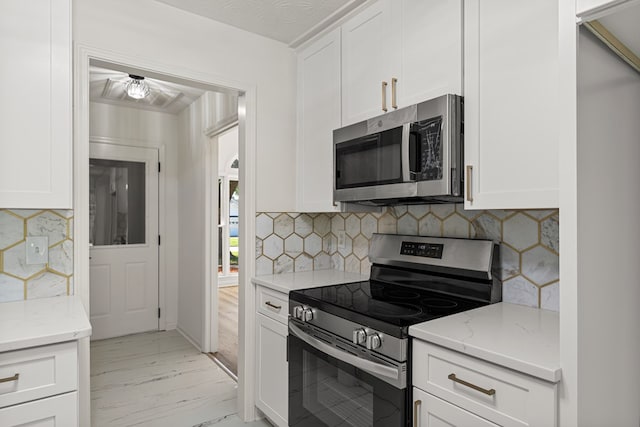 5437 Chatham Woods Ct, Columbus, GA 31907 - kitchen with appliances with stainless steel finishes, light marble finish flooring, light stone counters, and white cabinetry